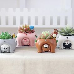 three elephant planters with succulents in them on a white tablecloth