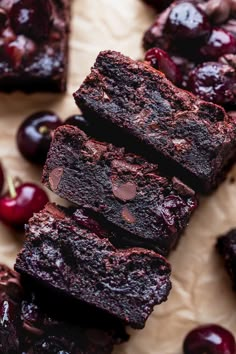 chocolate cherry brownies stacked on top of each other with cherries in the background