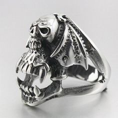 This one is scary! isn't it? specially designed for those who love horror and the dark outfits, if you recognize yourself then add this skull ring to your collection! Are you looking for a ring that will look perfectly good with your dark outfits? Well with this gothic ring design don’t go any further, it is made for you. This magnificent jewel is completely painted in silver except for some details that are painted in black. As you may have noticed it is composed of a jaw of a vampire skeleton Vampire Skeleton, Winged Skull, Gothic Ring, Skeleton Head, Gothic Vampire, Dark Outfits, Gothic Rings, Human Skull, Skull Head