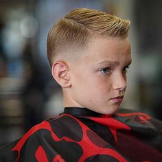 a young boy getting his hair cut at a barbershop with red and black designs on it