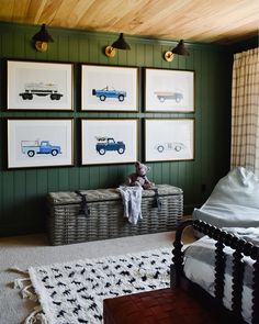 a bedroom with green walls and pictures on the wall, including a toy chest in front of a bed