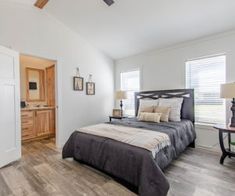 a bedroom with white walls and wood floors