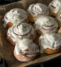 a bunch of doughnuts with white icing on them sitting in a box