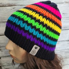 a multicolored knitted beanie hat sitting on top of a mannequin head