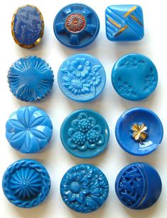 nine blue buttons with designs on them sitting next to each other in different shapes and sizes