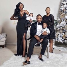 a family posing in front of a christmas tree