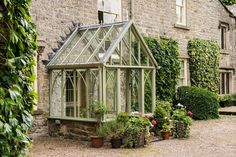 an old house with lots of plants growing around it