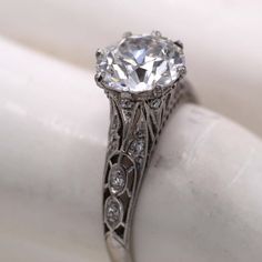 an antique style diamond ring with filigree accents