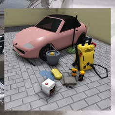 there is a pink car and other items on the ground next to it, including an oil can