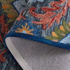 an up close view of a blue and red rug with flowers on it's edges