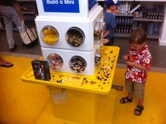 a young boy standing in front of a toy machine