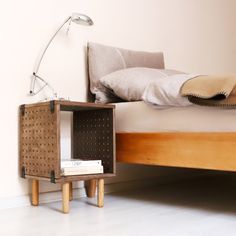 a bed with a wooden headboard and night stand on the floor next to it