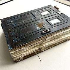 an old book is sitting on top of a table with some wires attached to it