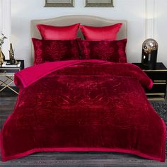 a bed with red comforters and pillows in a room