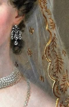 a close up of a woman in a wedding dress with pearls on her necklace and veil