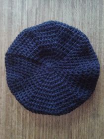 a blue knitted hat sitting on top of a wooden table