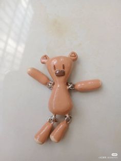 a brown teddy bear sitting on top of a white counter next to a window sill