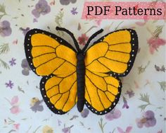 a yellow and black butterfly sitting on top of a flower covered table cloth with the words,