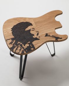 a wooden table with a drawing of a man's face on the top and legs