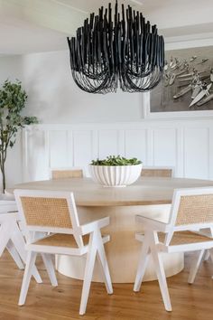 a dining room table with chairs around it and a bowl on the table in front of it