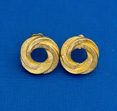 For sale is a gold tone pair of stud earrings with spiral ring-shaped design. Shipping:  I'll ship out your item either the same day or the next day depending on what time you order. Most items will be placed in a jewelry box and shipped USPS first class in a bubble mailer. Keywords Vintage Stud Earrings, Gold Tone Earrings, Spiral Earrings, Vortex Earrings, Hurricane Swirl Earrings, Made by Avon Vintage Stud Earrings, Spiral Ring, Stud Earrings Gold, Swirl Earrings, Spiral Earrings, Bubble Mailer, Gold Earrings Studs, Earrings Gold, Jewelry Earrings Studs