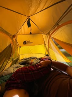 a person laying in a tent with their feet up