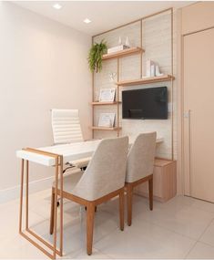 there is a desk with two chairs and a television on the wall in the room