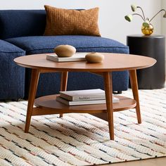 a living room with a blue couch and coffee table in the middle, on a rug