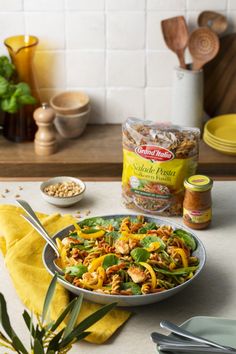 a bowl filled with food sitting on top of a counter next to some utensils