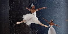 three ballerinas in white tutus and tiaras are performing on stage with snow falling all around them