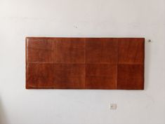 a brown leather wall hanging on a white wall