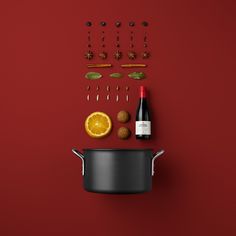 an assortment of cooking utensils and ingredients on a red background with a wine bottle