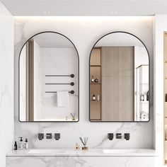 two mirrors on the wall above sinks in a bathroom with marble counter tops and cabinets