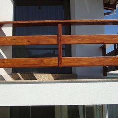 a wooden balcony railing in front of a white building