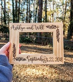 a person holding up a wooden frame with the words happily and will written on it