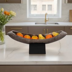 a bowl filled with fruit sitting on top of a kitchen counter