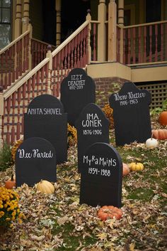 tombstones with names and pumpkins in front of a house decorated for halloween time