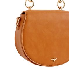 Crafted from certified vegan leather in classic tan, this curved satchel design evokes a sense of country life, reminiscent of a classic equestrian saddle bag. Complete with a top handle, an adjustable cross-body strap and a magnetic fastening, all designed to keep your most precious treasures safe and secure. Wipe clean with damp cloth Brown Saddle Bag, Cognac Saddle Bag For Work, Brown Saddle Bag With Detachable Strap, Brown Bags With Horsebit Detail For Everyday Use, Brown Saddle Bag With Removable Pouch For Work, Brown Horsebit Satchel Shoulder Bag, Brown Satchel Shoulder Bag With Horsebit Detail, Chic Saddle Flap Bag, Chic Saddle Satchel With Adjustable Strap