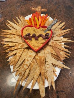 a heart shaped plate filled with chips and vegetables