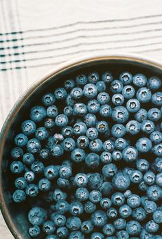 a bowl full of blueberries sitting on top of a table