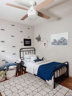 a bed room with a neatly made bed and a ceiling fan