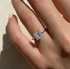 a woman's hand with a diamond ring on it