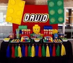 a table topped with lego themed desserts and candy