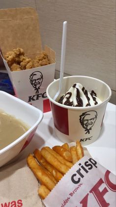 two cups of ice cream and some fries on a table