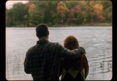 a man and woman looking out over the water