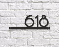 a metal sign on a brick wall that reads'618'in the center