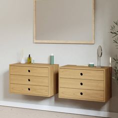 two wooden dressers sitting next to each other in front of a mirror on the wall