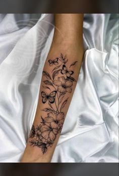 a woman's arm with flowers and butterflies on it