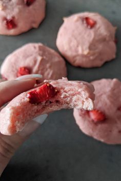 a hand holding a strawberry shortbread with powdered sugar