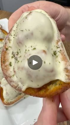 someone is holding an open faced sandwich with cheese on it